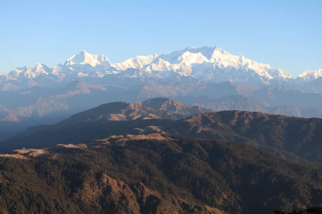 Breathtaking view of snow-capped Mount Kanchenjunga under clear blue skies.