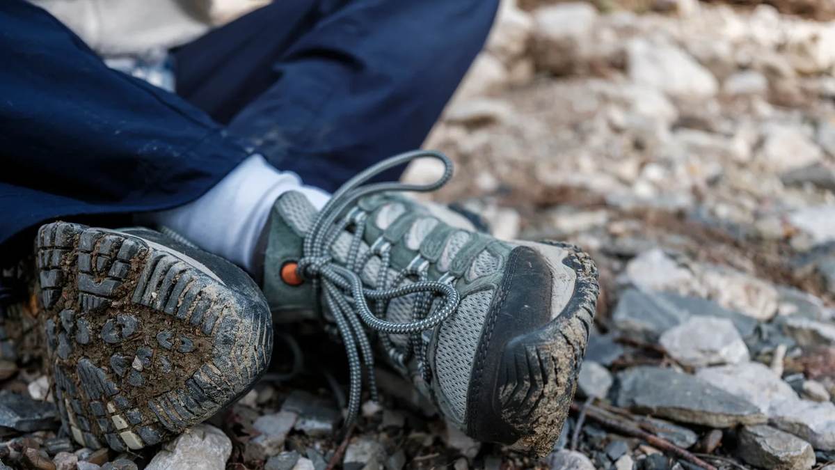 Worn-in hiking boots on a mountain trail — a boot that has already taken the shape of your foot is the one that will not blister you on a long walking day