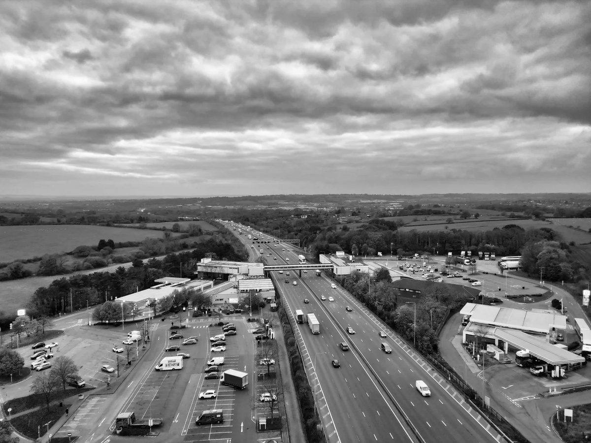 Aerial view of the M1 motorway and a service area under heavy cloud