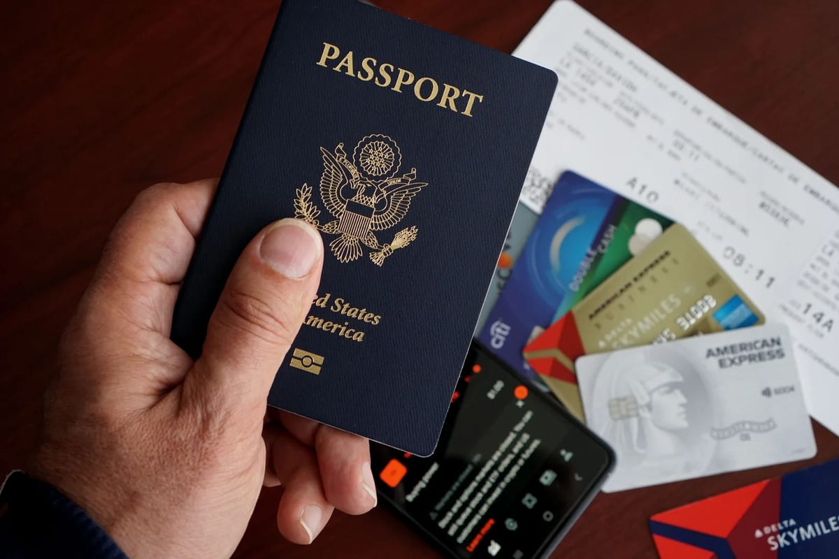 A US passport with credit cards, travel tickets and a phone on a table