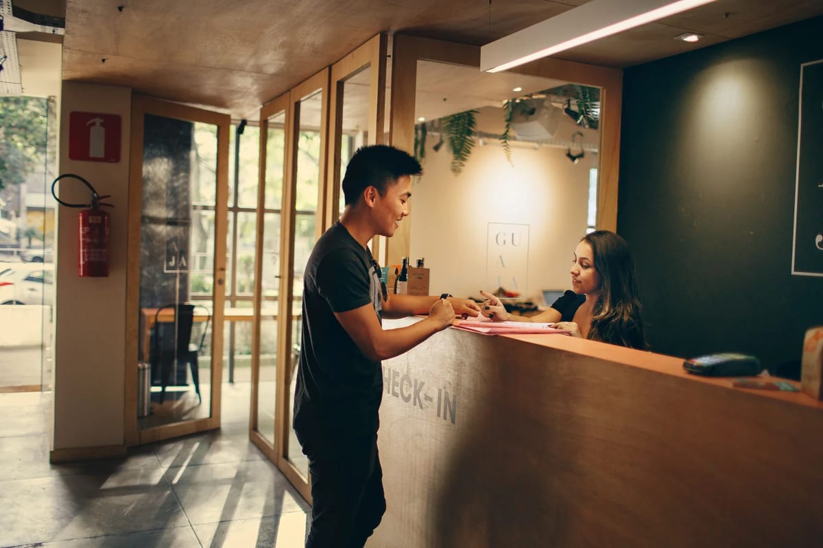 A guest checking in at a hotel reception desk