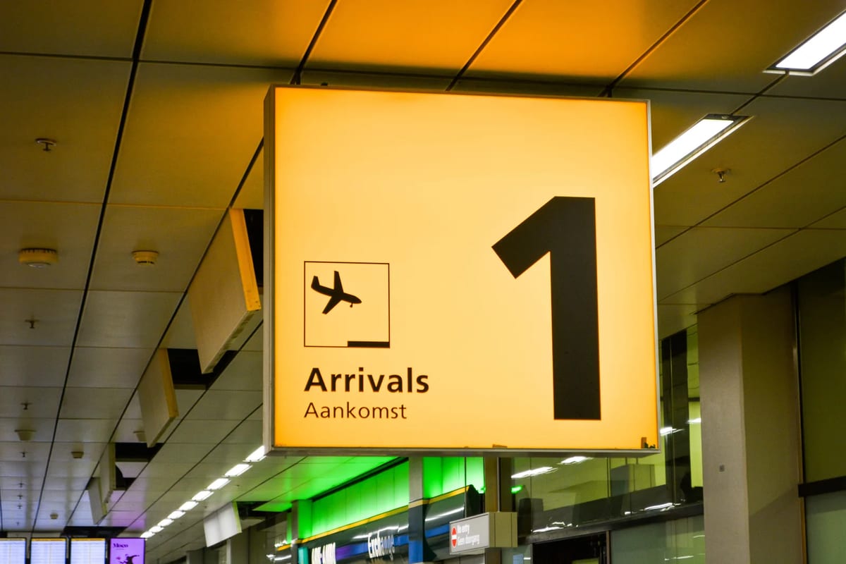 Yellow arrivals sign with an aeroplane symbol inside an airport terminal