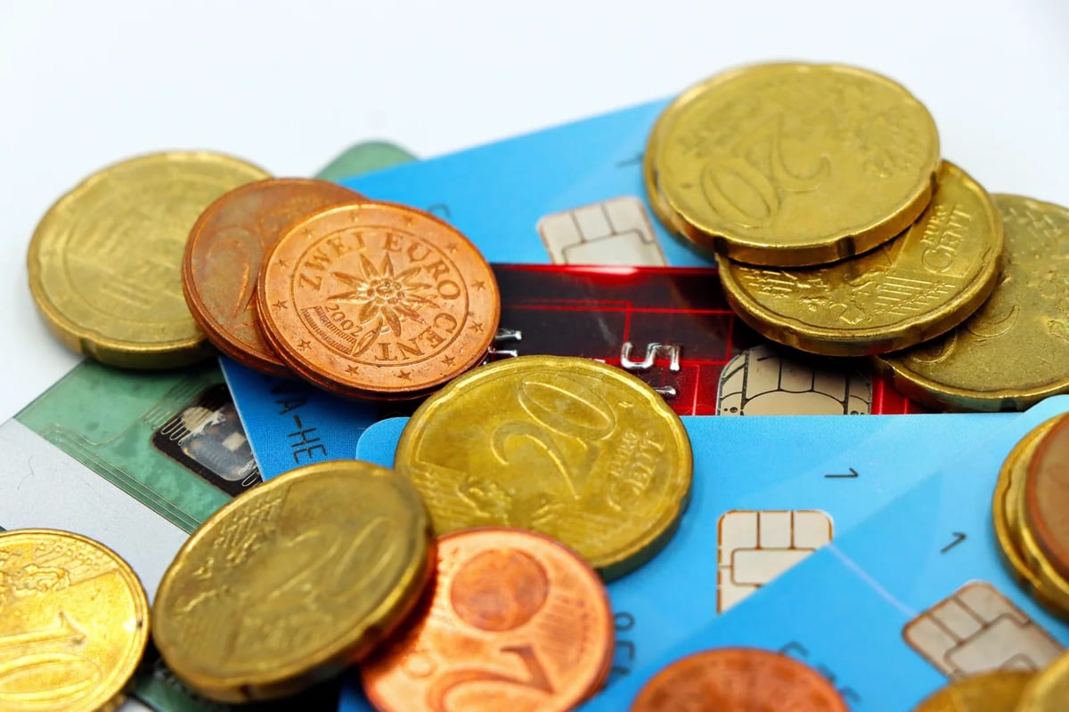 Euro coins lying beside credit cards
