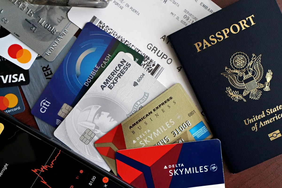 Travel essentials on a table including a passport, credit cards and a boarding pass