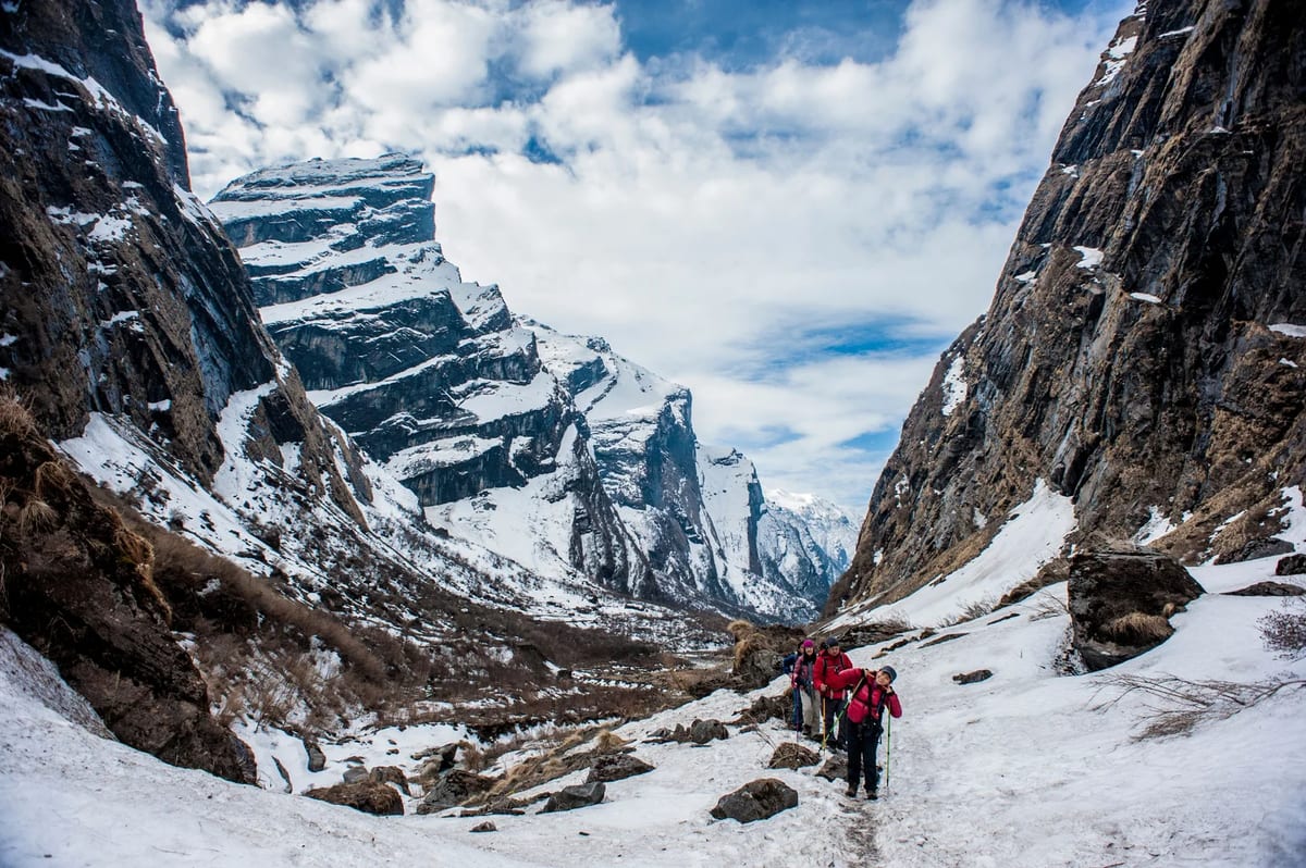 Hikers crossing snow-covered mountains in Nepal