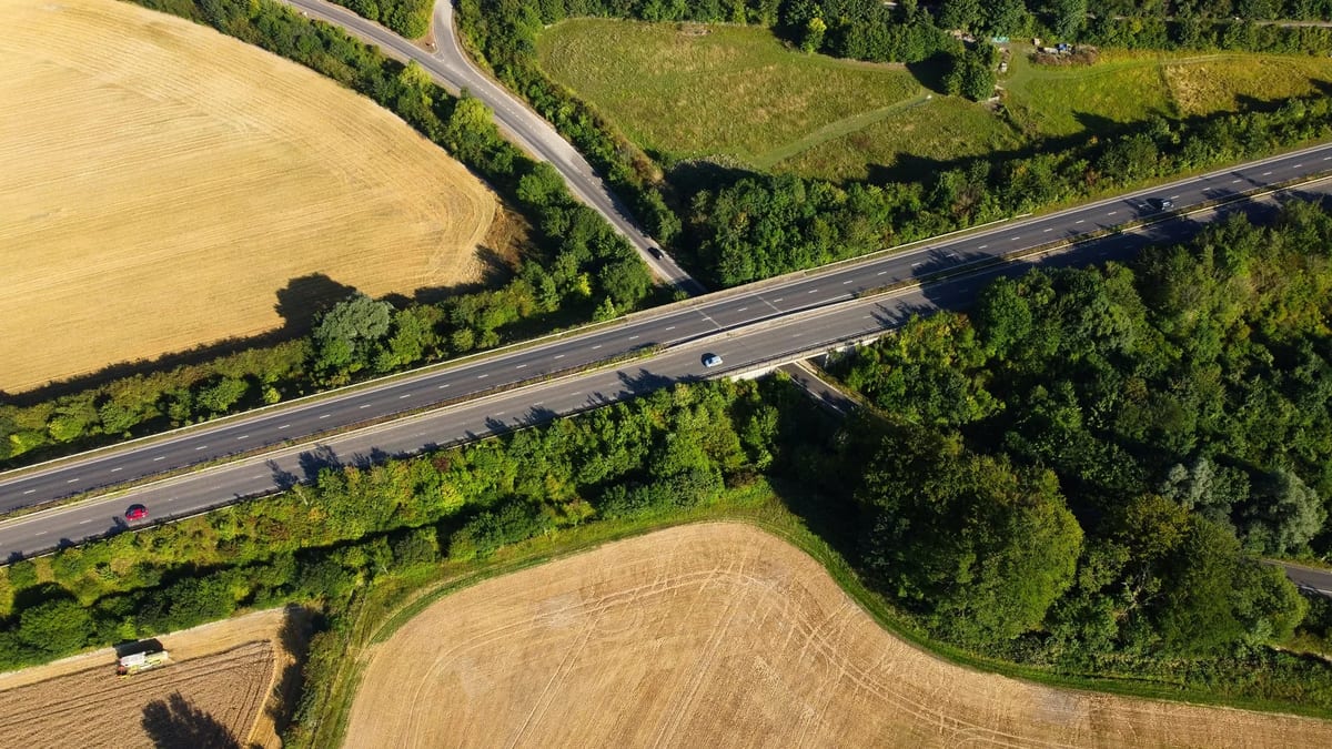 An aerial view of a highway running through green fields in Bedfordshire, England