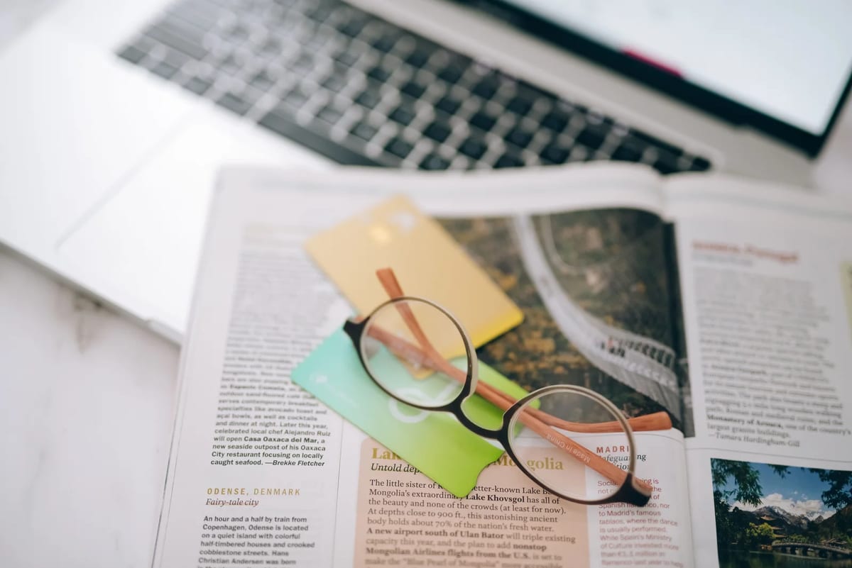 Credit cards, reading glasses and a magazine on a table