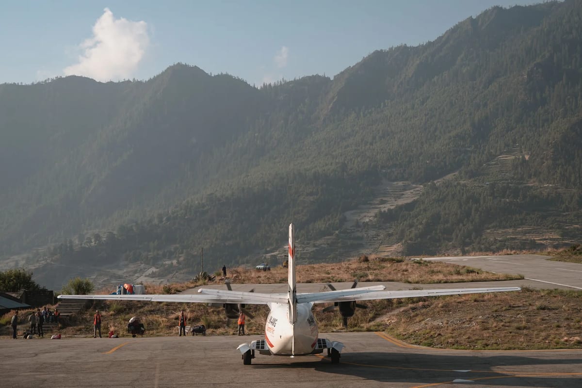 Small aircraft on a tarmac with mountains behind