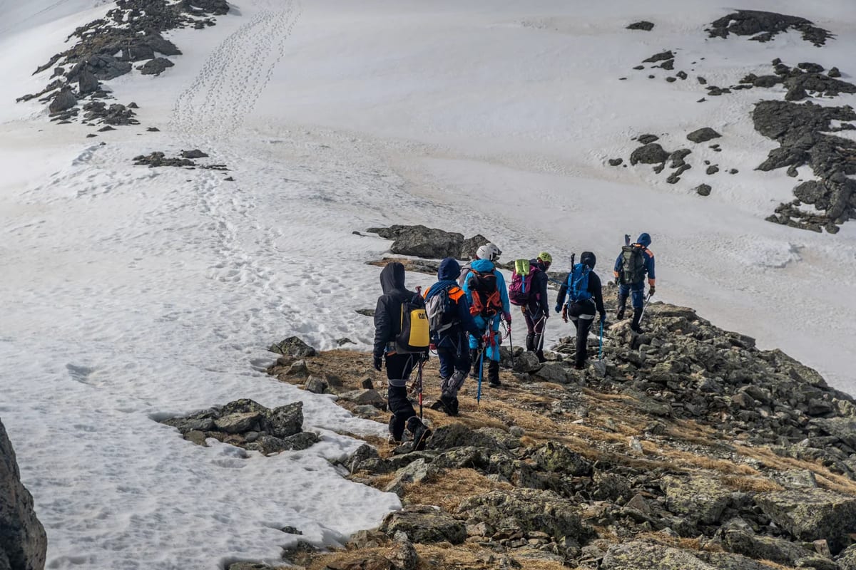 Group hiking on a snowy mountain ridge