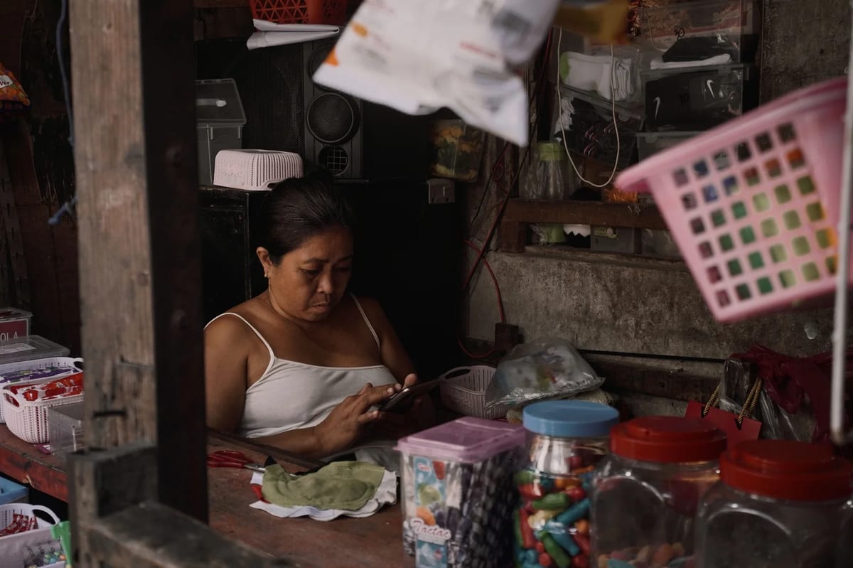 A woman using her phone inside a small local shop