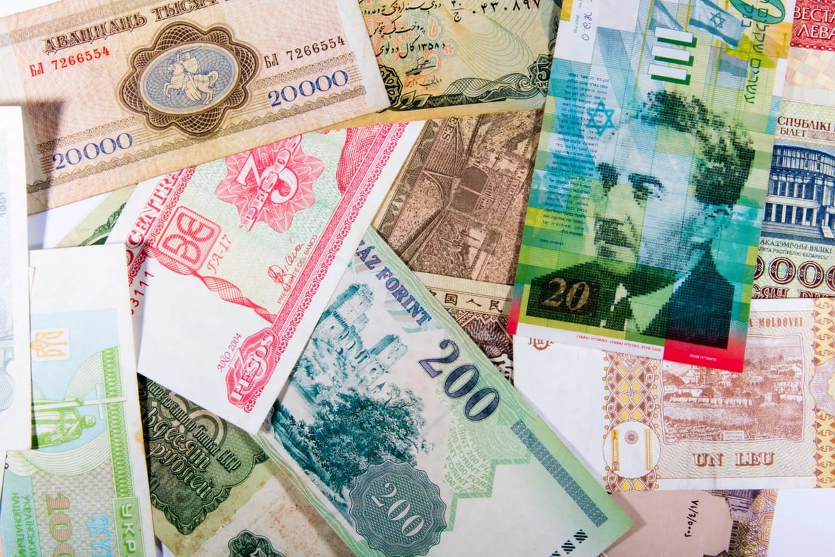 Banknotes from several different countries spread out on a table