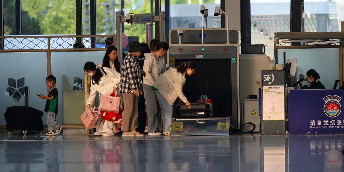 Travellers passing through airport security screening at a terminal