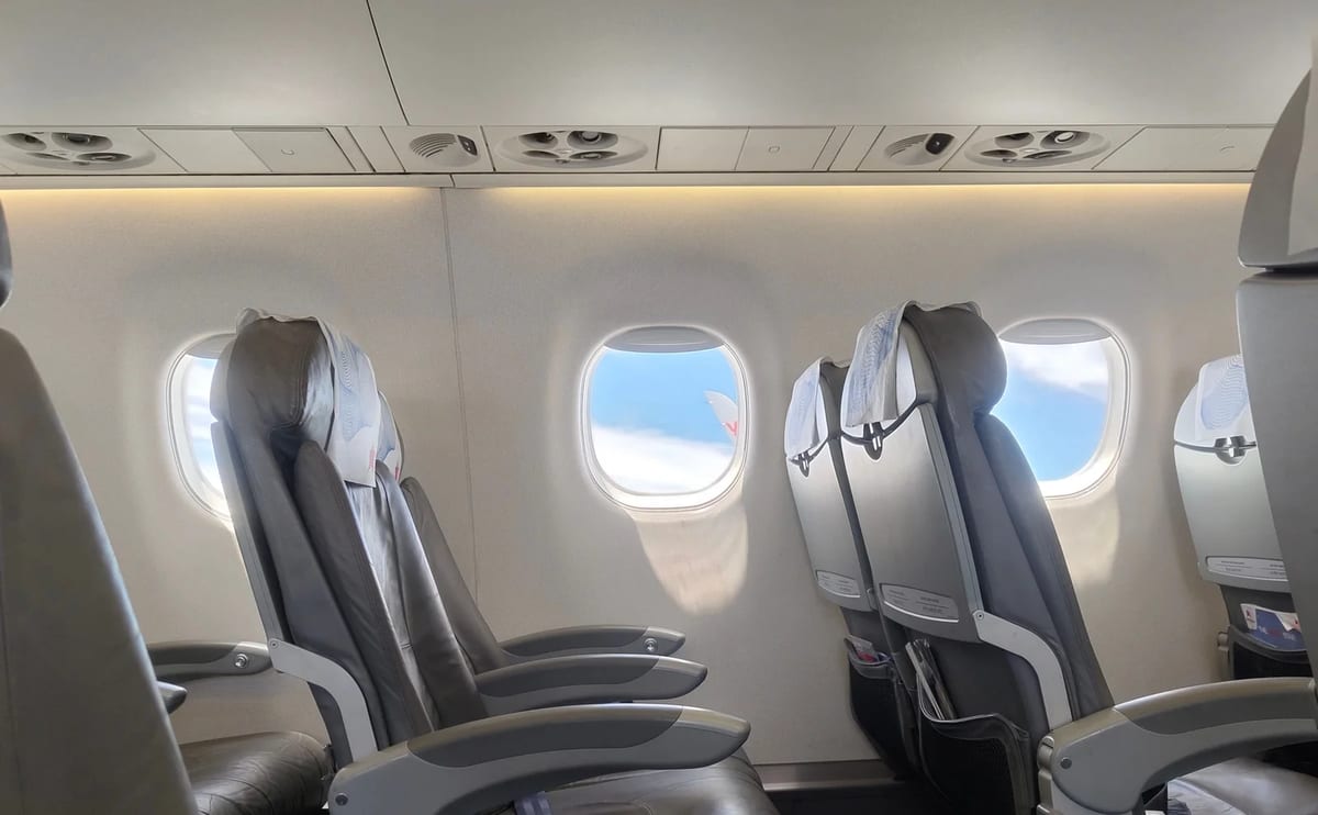 Airplane cabin with a window view of clouds