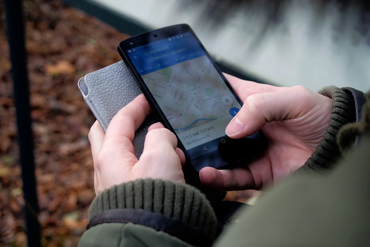 Hands using a map app on a smartphone outdoors