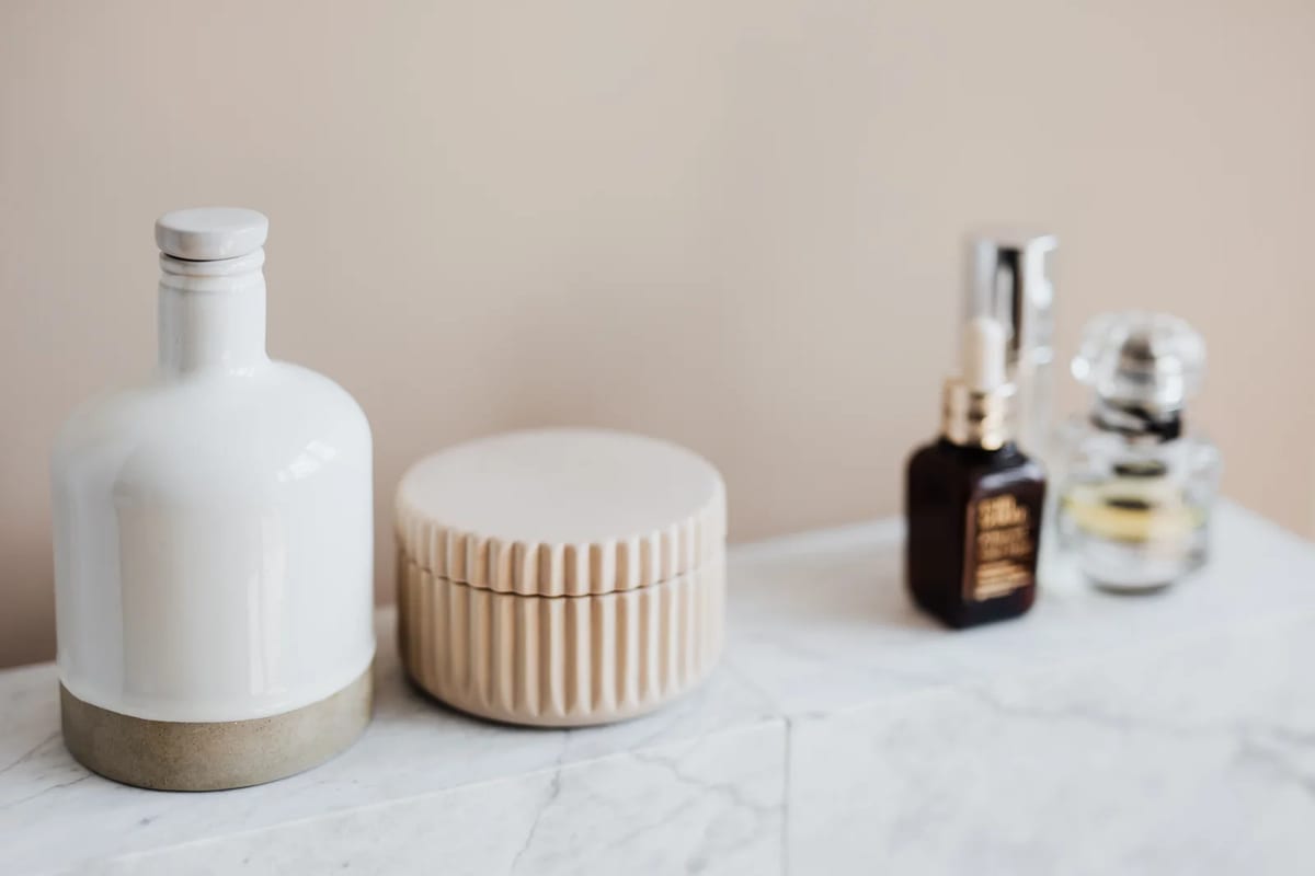 Small refillable containers for cream and shampoo beside skincare bottles