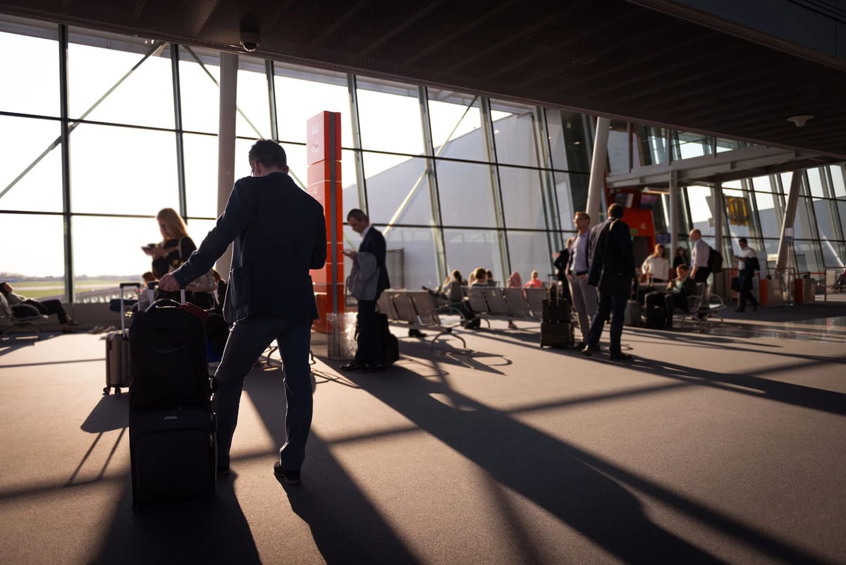 Travellers with carry-on luggage in a busy terminal