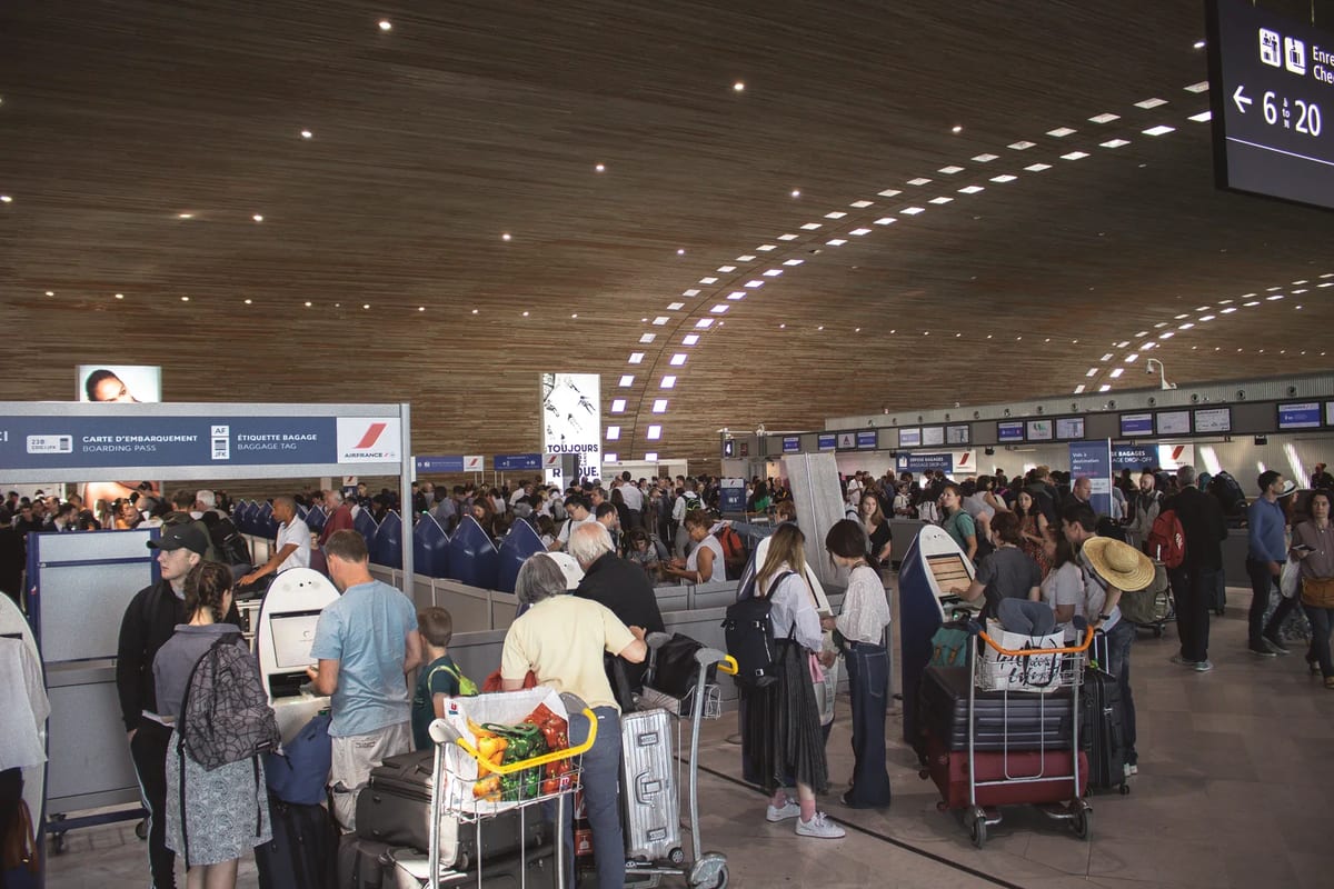 A crowded airport terminal with travellers in line
