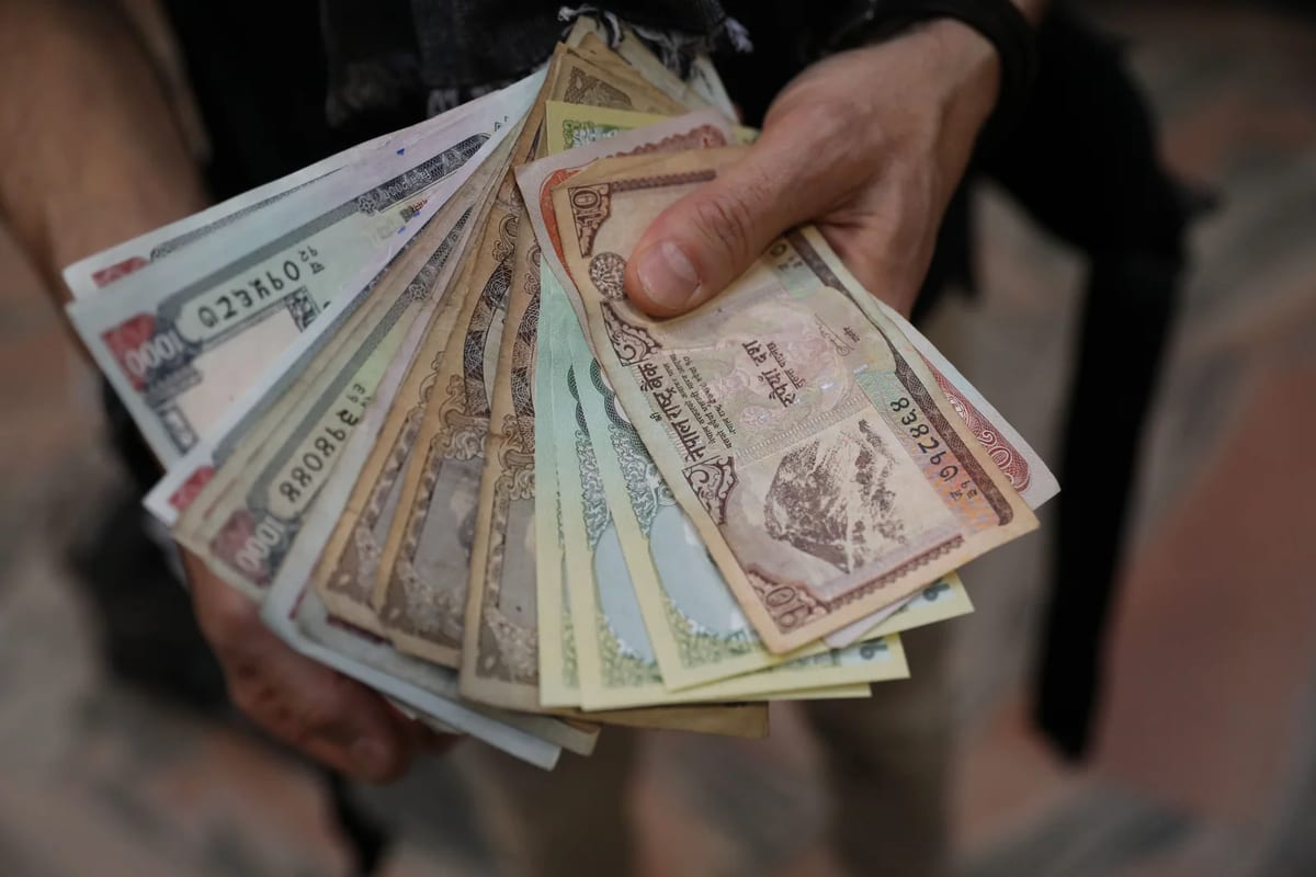 Hands holding a fan of Nepalese rupee banknotes