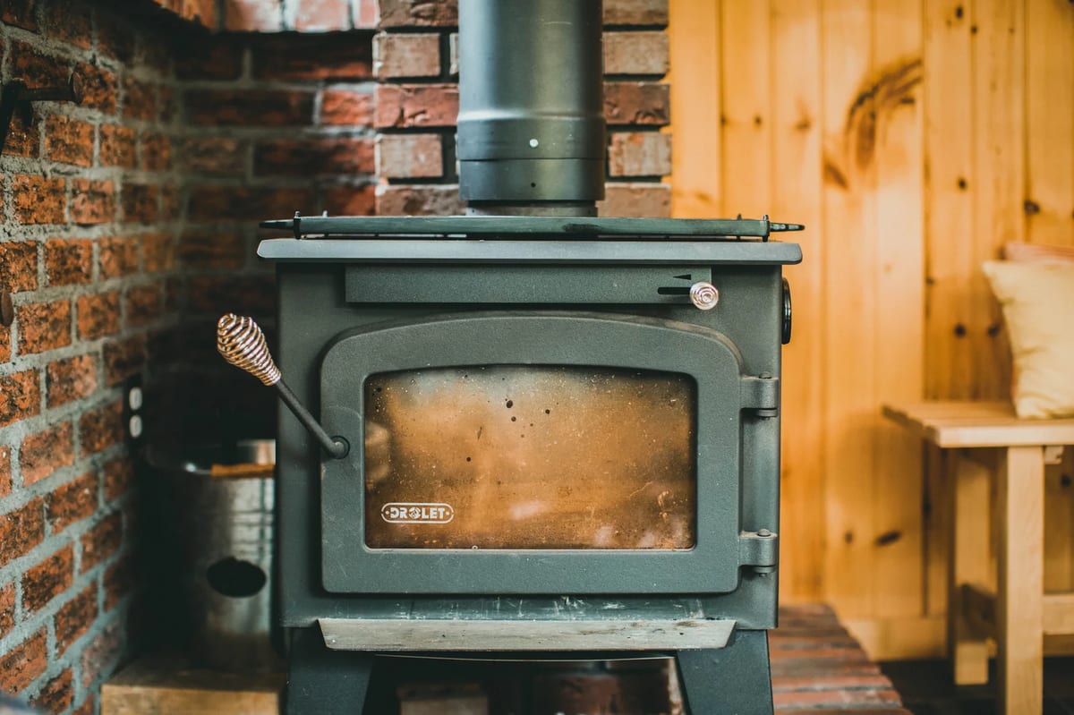 A wood stove burning in a rustic mountain lodge interior