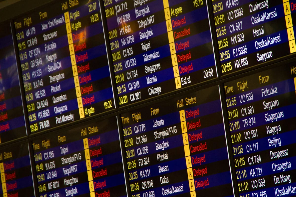 Airport departures board with several flights marked delayed and cancelled