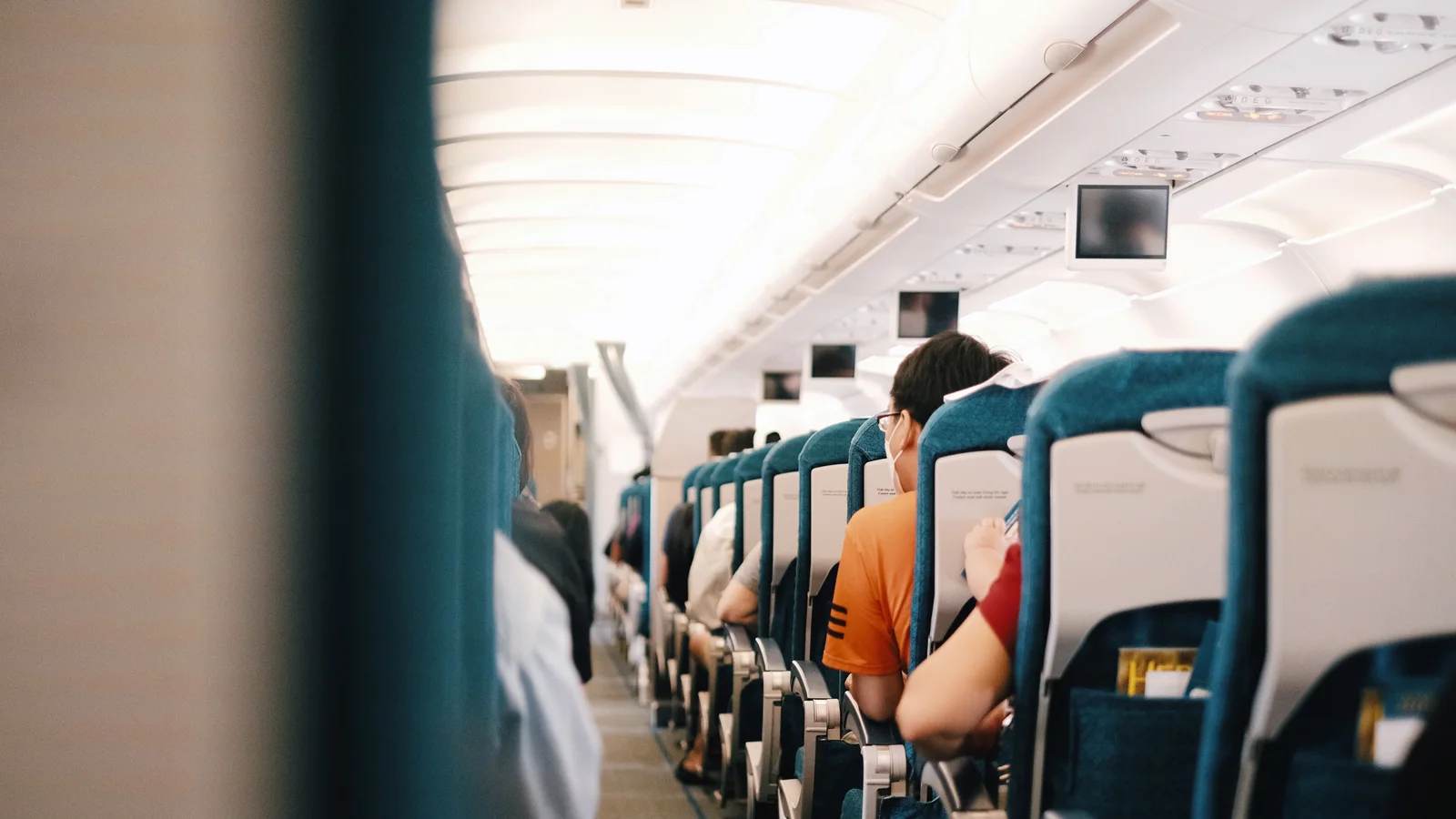 Passengers seated in rows inside an airliner cabin during a flight