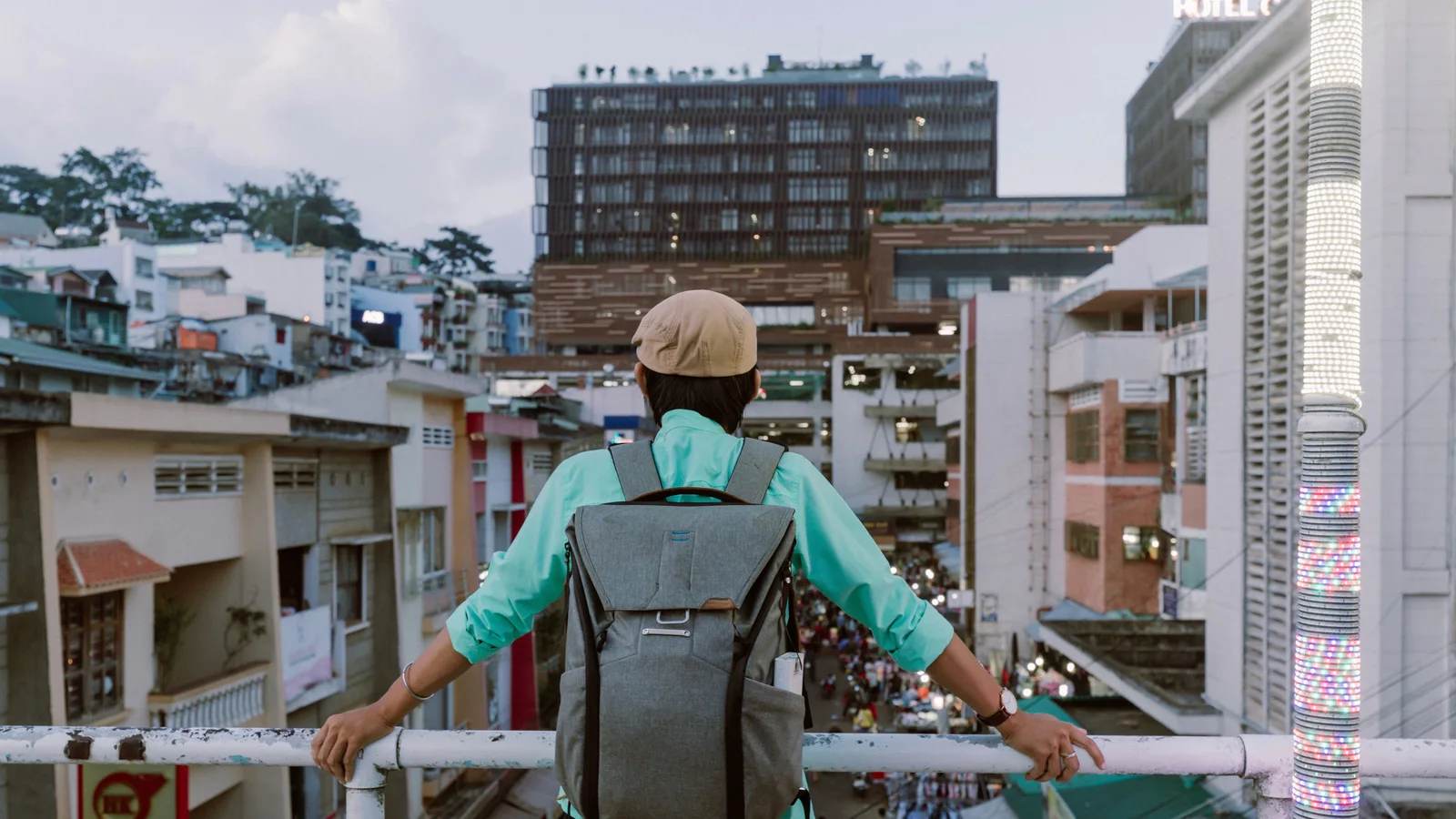 A traveller with a backpack looking down at a busy city street