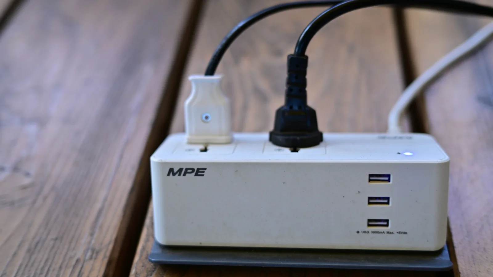 A power strip with USB ports and plugs on a wooden table