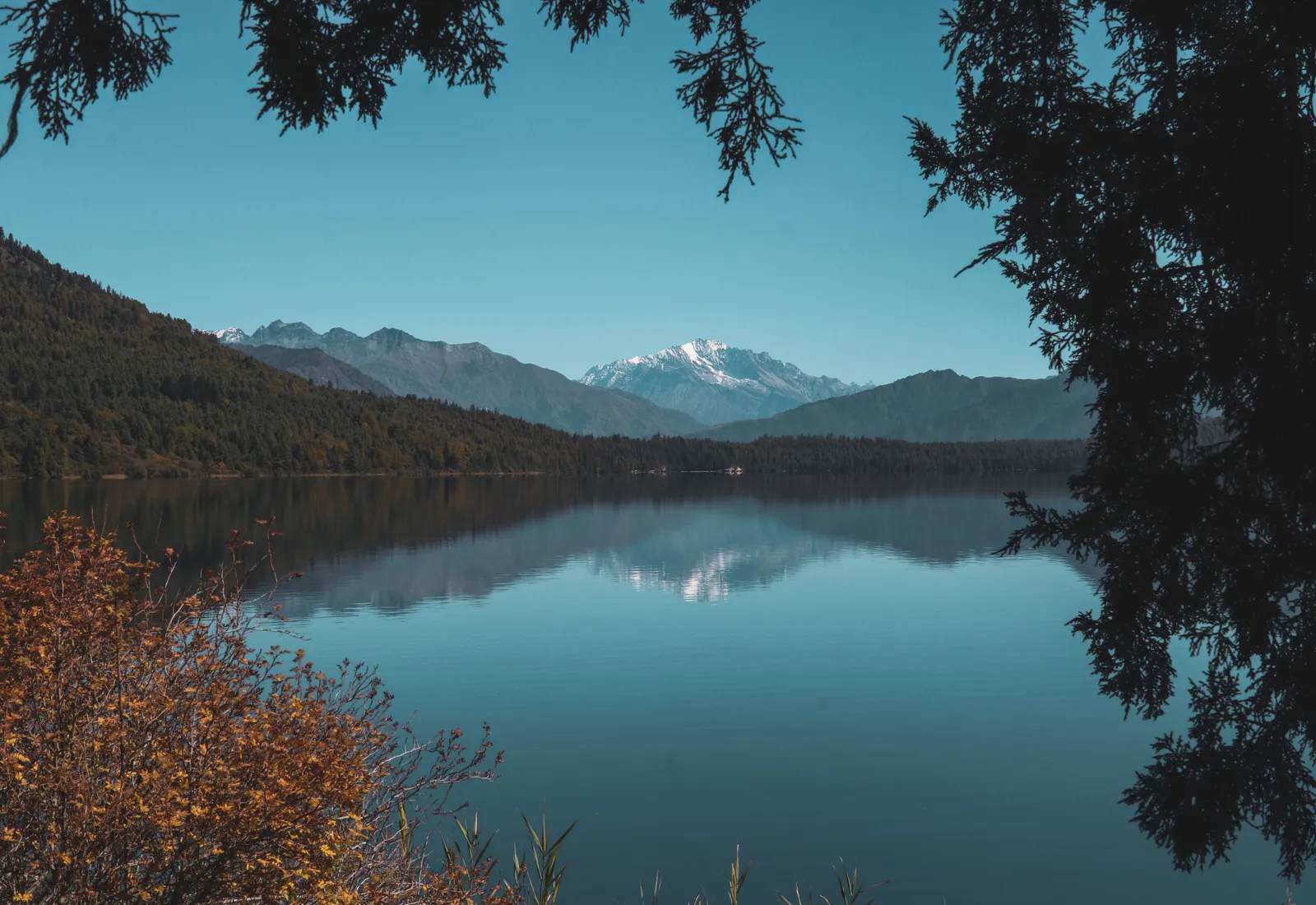 Rara Lake with snow peaks reflected in still water