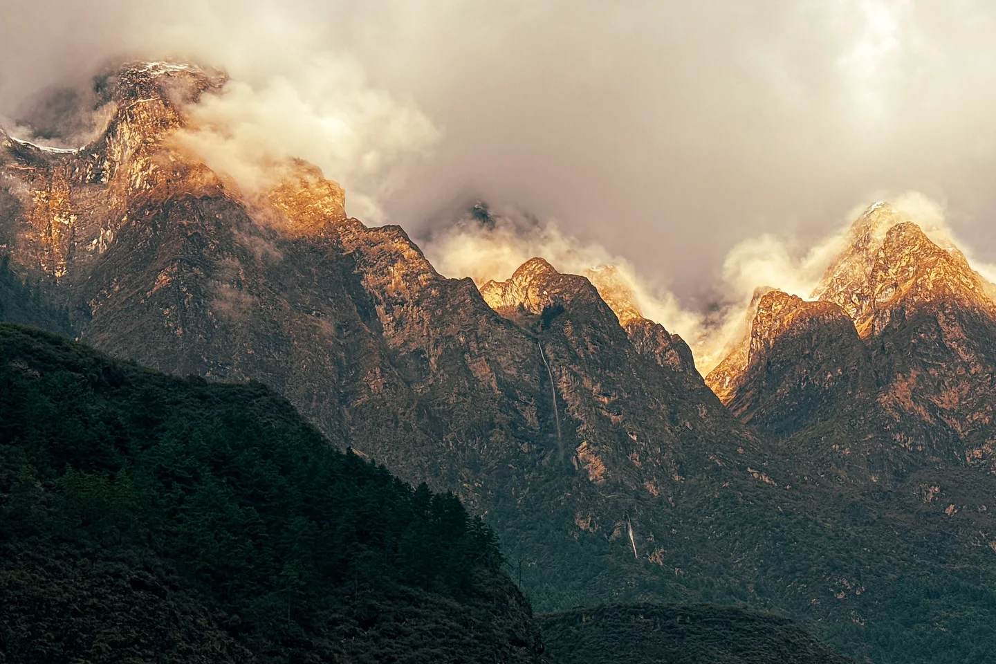 Golden dawn light on a cloud-wrapped Himalayan ridge above the Manaslu trail in Nepal