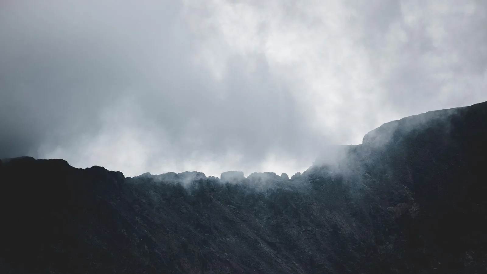 A dark mountain ridge disappearing into cloud