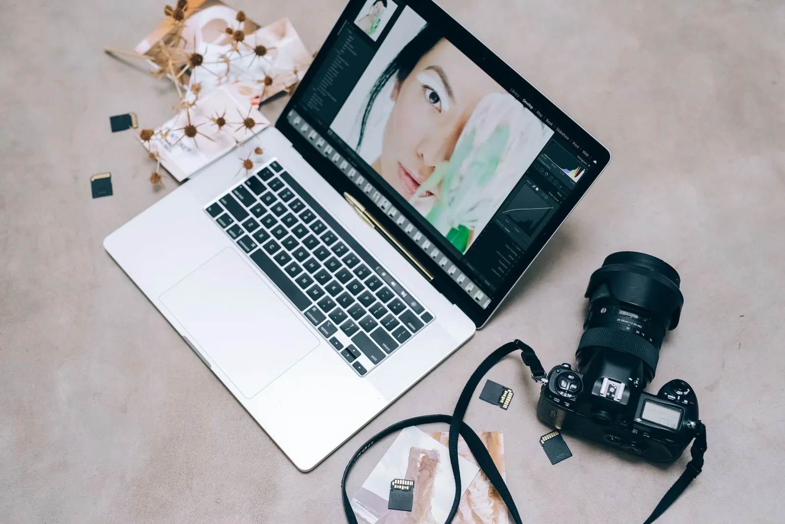 A camera memory card, a laptop and a small external drive on a desk — copying and backing up travel photos