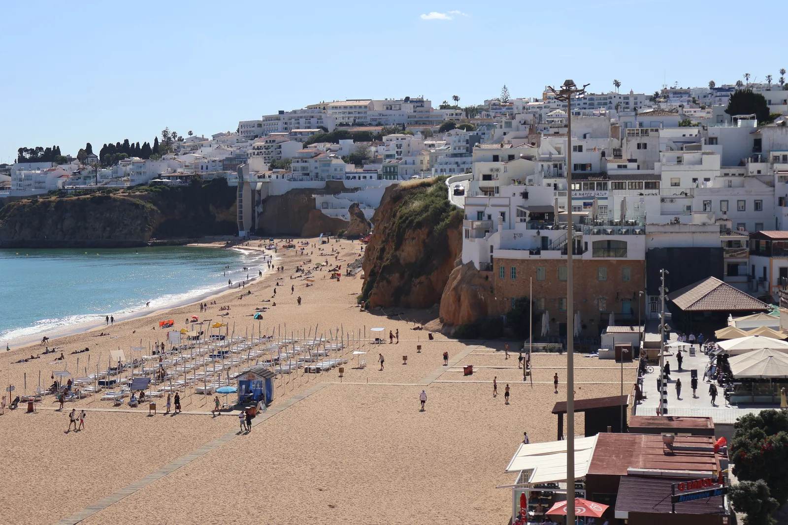 Whitewashed cliffs above a turquoise cove on Portugal's Algarve coast — one of Europe's most affordable retirement destinations, 2026