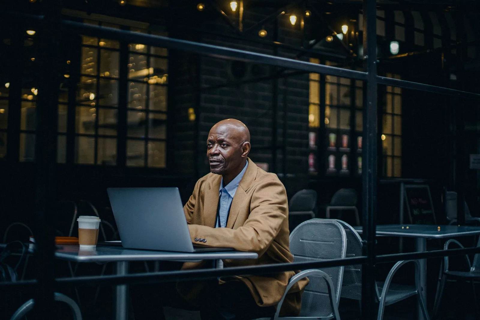 A remote worker using a laptop at a cafe table while travelling abroad