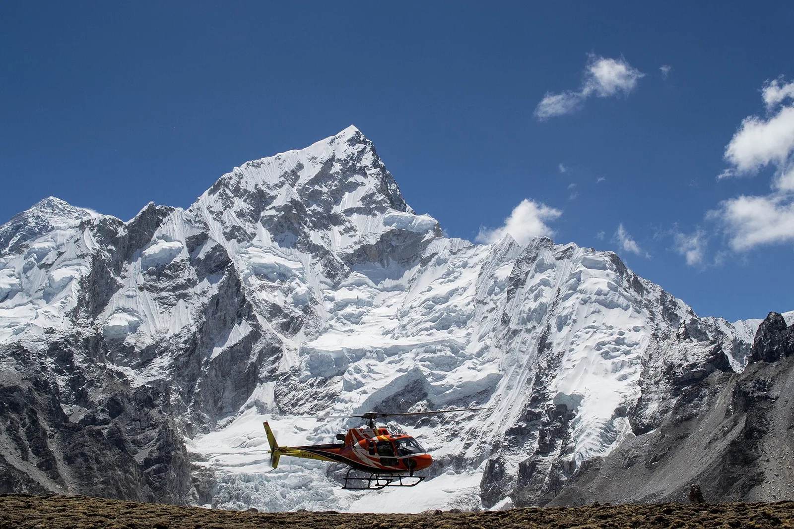 A helicopter departs Everest Base Camp in Nepal's Khumbu — a high-altitude evacuation can cost thousands of dollars, 2026