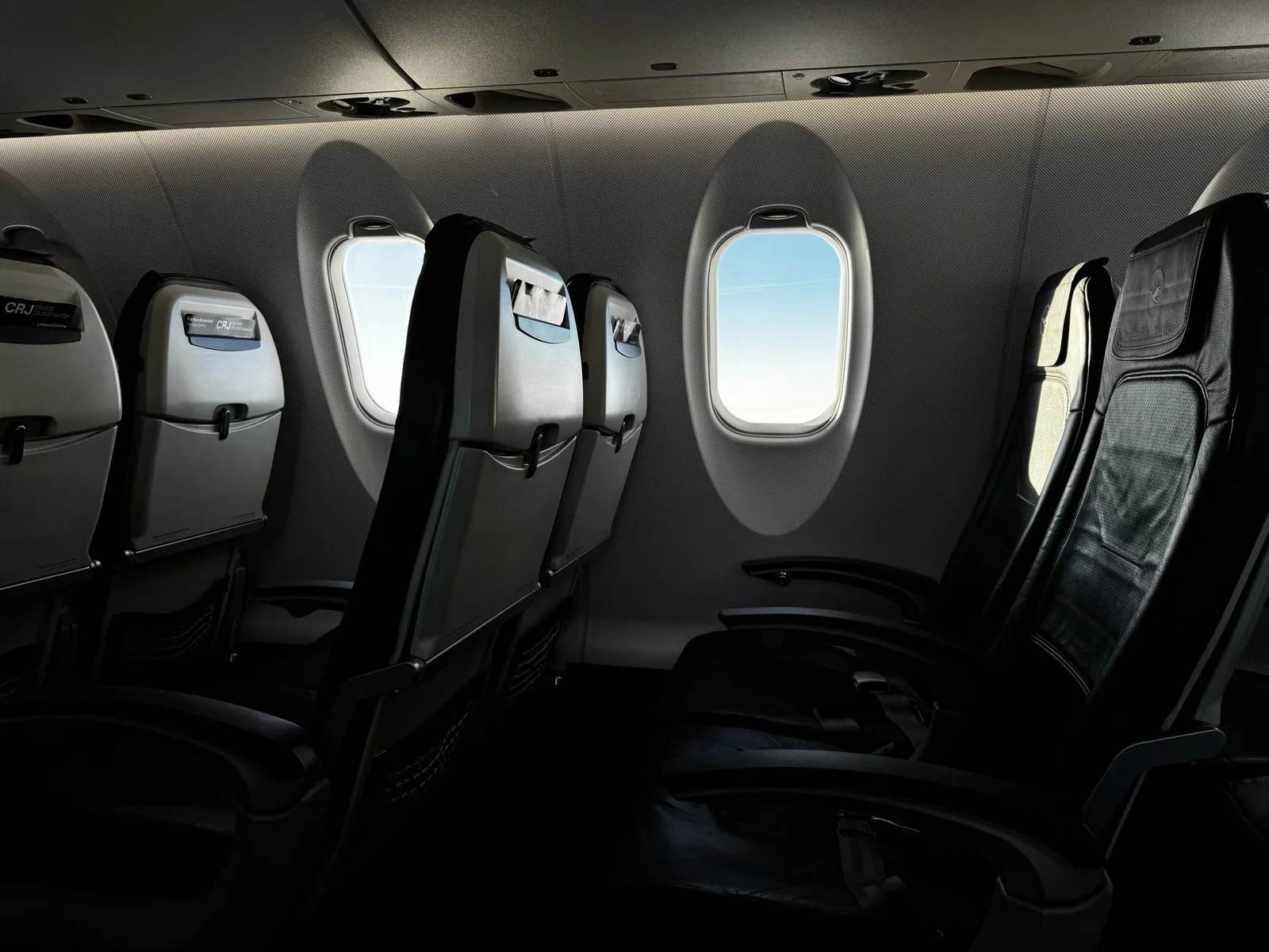Empty seats and windows inside an airliner cabin with daylight streaming in, evoking the long-haul flights that cause jet lag