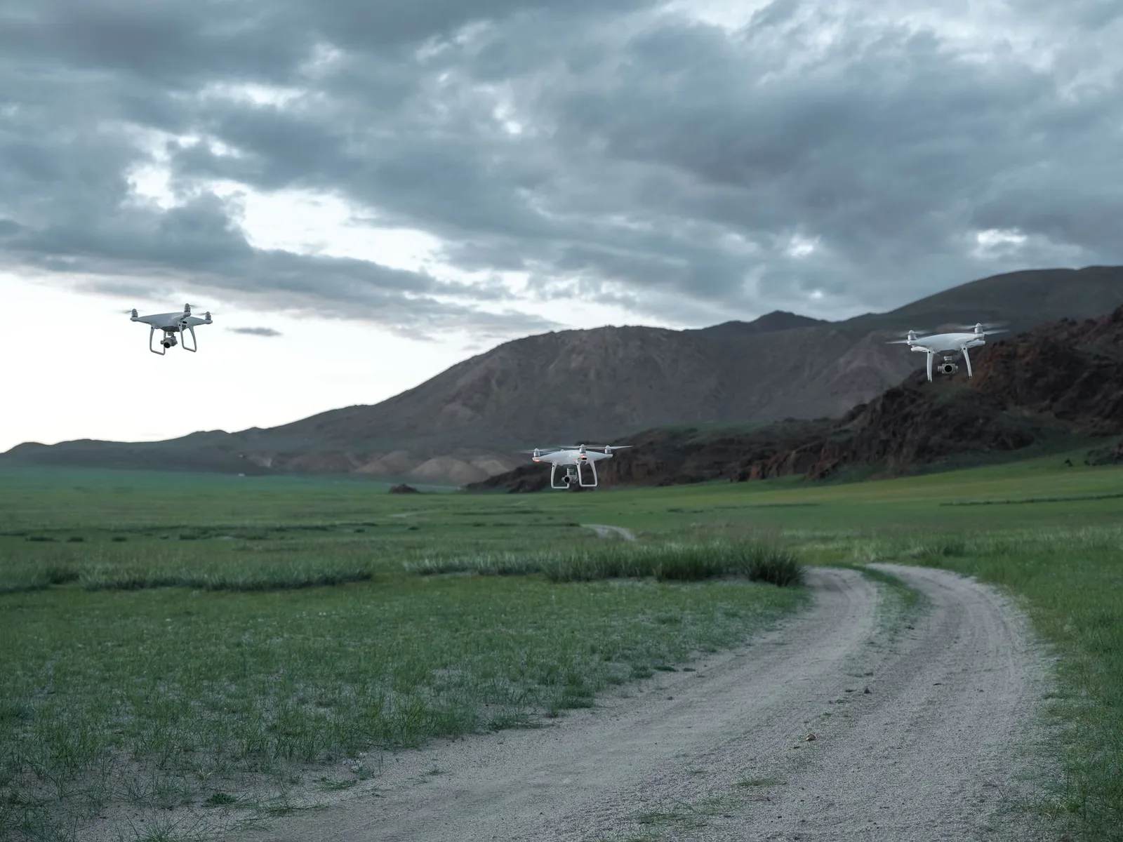 A camera drone hovering in the air over an open mountain landscape — travelling abroad with a drone means checking each country’s rules first