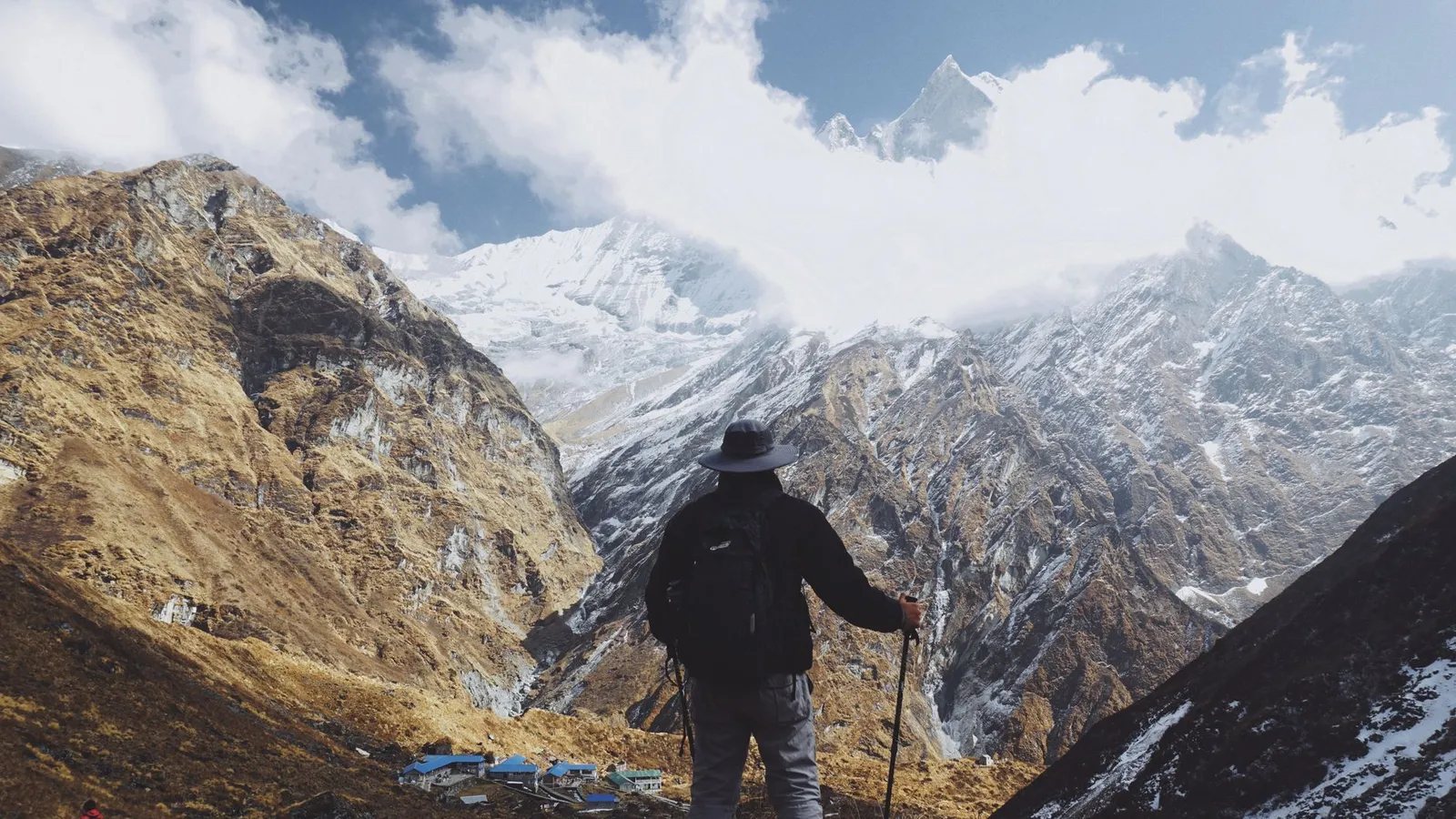 Trekkers on a Himalayan trail beneath snow-capped Nepal peaks