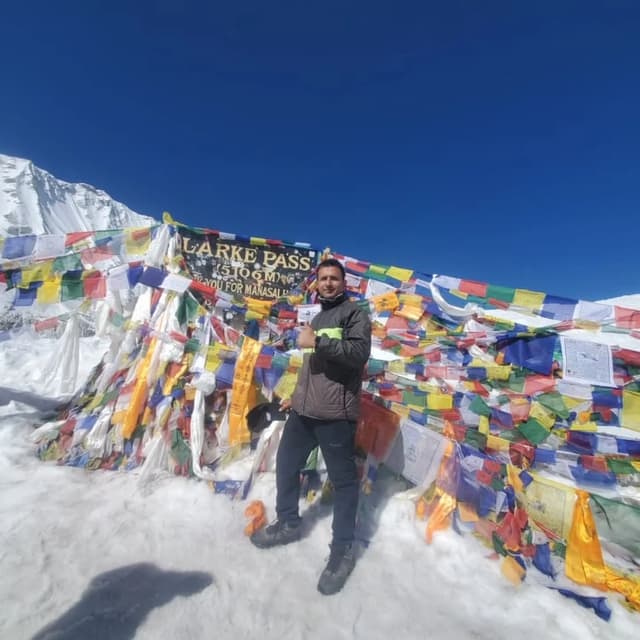 Trekker among prayer flags at Larke Pass 5,106m, Manaslu Circuit