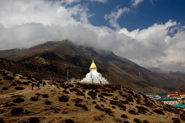 A white stupa above Dingboche with cloud rising up the valley