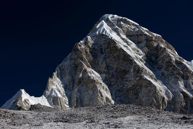 A snow peak against a dark sky before dawn above Kala Patthar