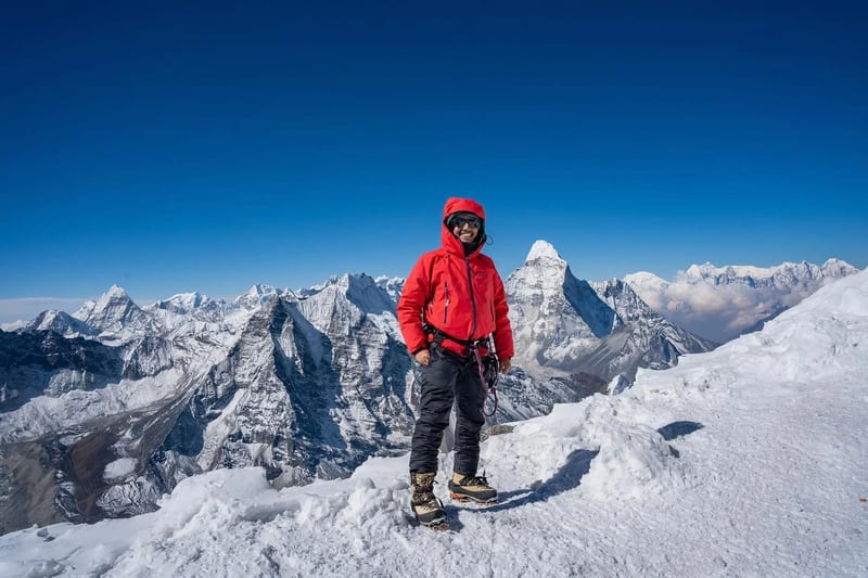 Trekker on the summit ridge of Island Peak at 6,189m with Himalayan giants behind